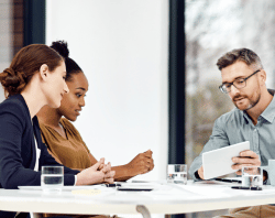 three people at table talking